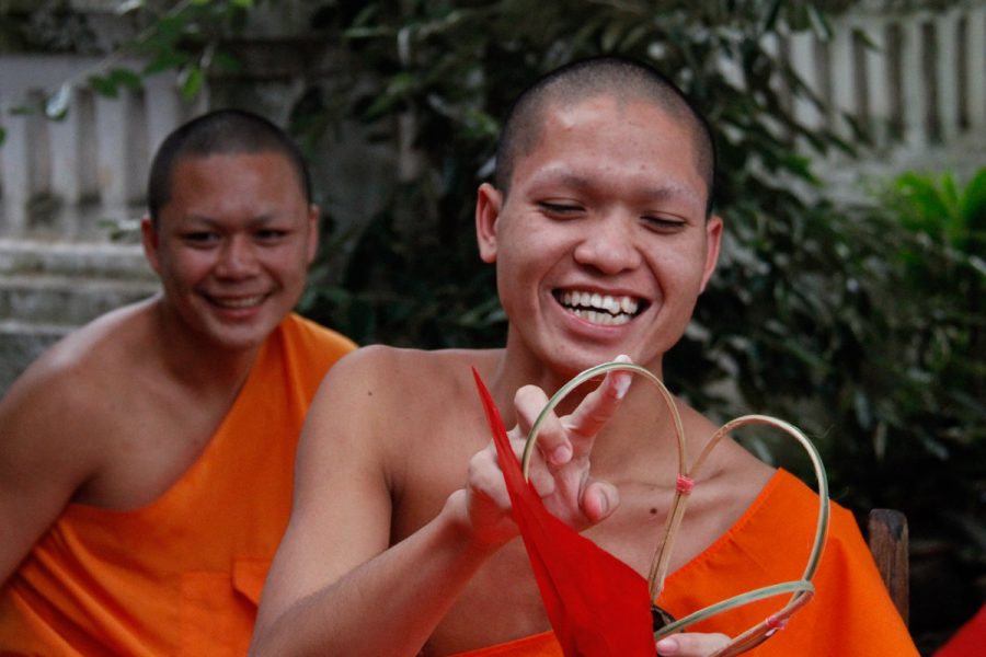 Dans la cour d'un monastère, des moines sont occupés à fabriquer des lampions en papier et bambou
